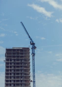 Construction site with cranes and building with blue sky background