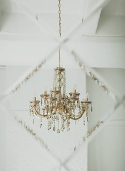 antique classic chandelier is reflected in the mirror of the apartment