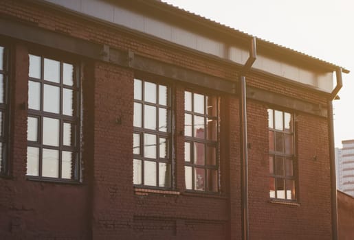 old brick building with windows at sunset