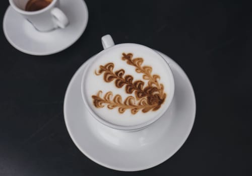 two mugs of coffee on the table. cappuccino with milk foam and espresso