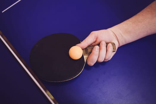 hand with rocket hits the ball. ping pong