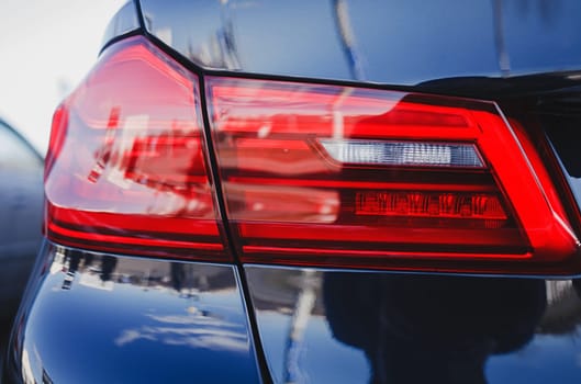 Detail on the rear light of a blue modern car