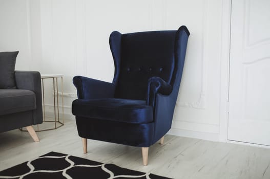 Beautiful living room with blue armchair in modern interior