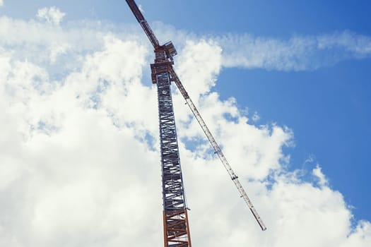 Construction crane against the blue sky background 