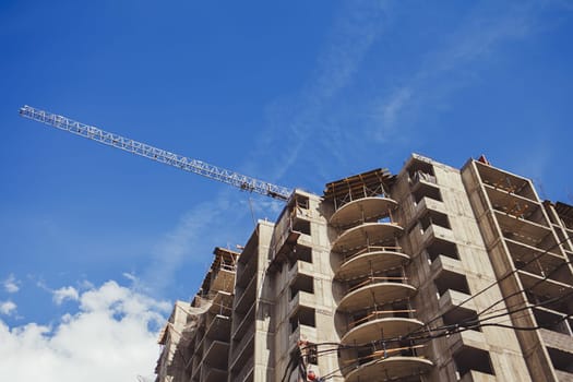 Construction site background. Hoisting crane and new multi-storey buildings.