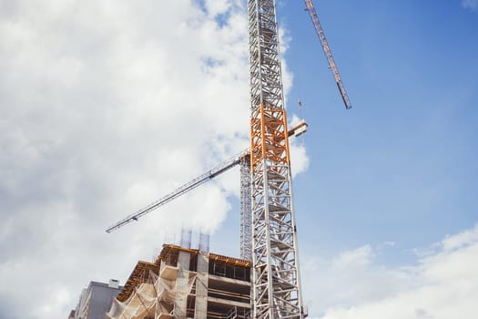 Cranes and building under construction against sky 