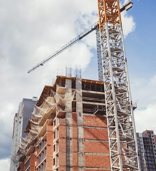 Cranes and building construction site against blue sky 