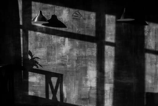 Dark empty room with sunlight coming through windows and shadows