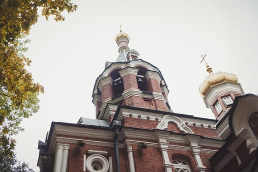 brick old Church on the background of autumn leaves