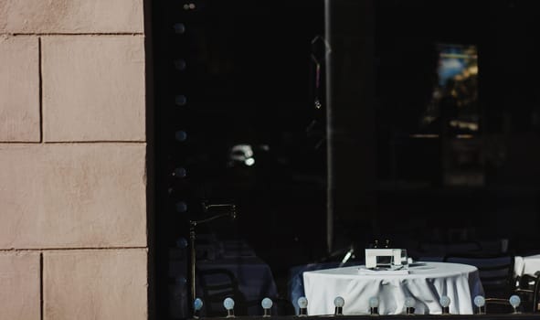 Window of an old bistro with empty tables in Europe