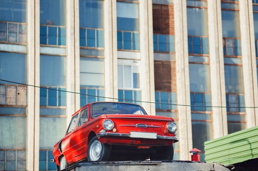 Minsk, Belarus - August  2019. Colorful red soviet retro car near old building. 