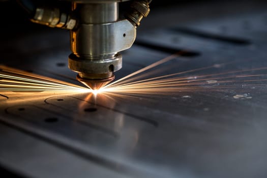 Cutting of metal. Sparks fly from laser, close-up