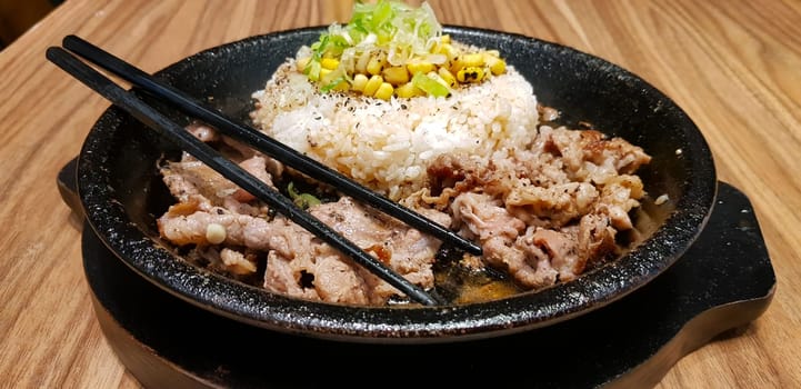 selective focus grilled beef steak with korean sauce bulgogi on top of rice with slice of pepper and sweet corn - korean food style