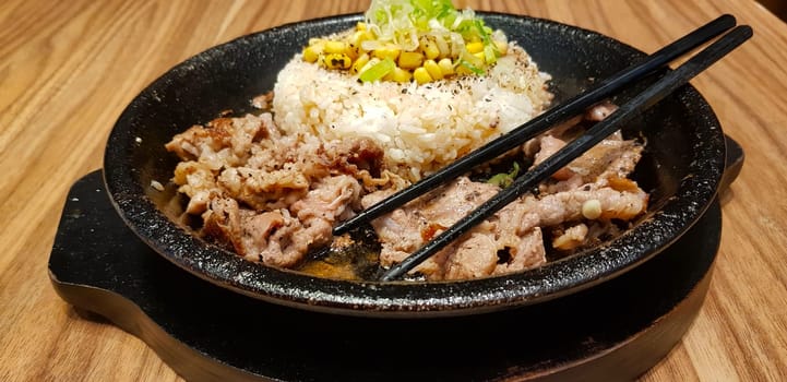 selective focus grilled beef steak with korean sauce bulgogi on top of rice with slice of pepper and sweet corn - korean food style