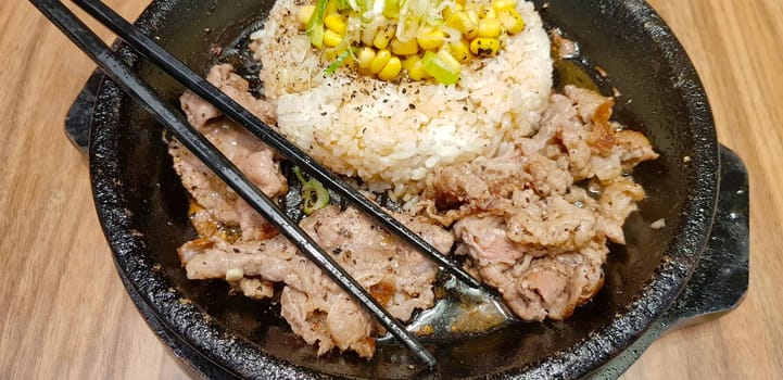 selective focus grilled beef steak with korean sauce bulgogi on top of rice with slice of pepper and sweet corn - korean food style