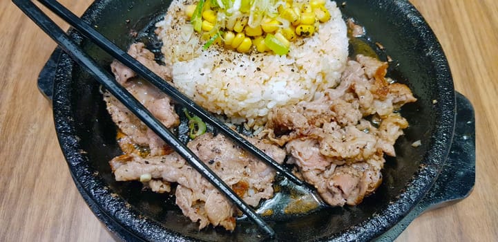 selective focus grilled beef steak with korean sauce bulgogi on top of rice with slice of pepper and sweet corn - korean food style