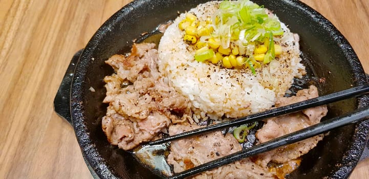 selective focus grilled beef steak with korean sauce bulgogi on top of rice with slice of pepper and sweet corn - korean food style