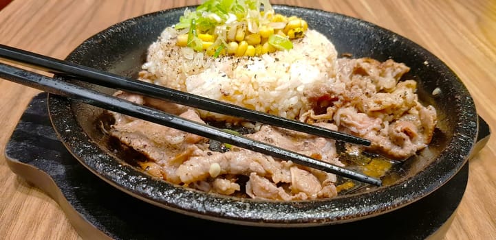 selective focus grilled beef steak with korean sauce bulgogi on top of rice with slice of pepper and sweet corn - korean food style