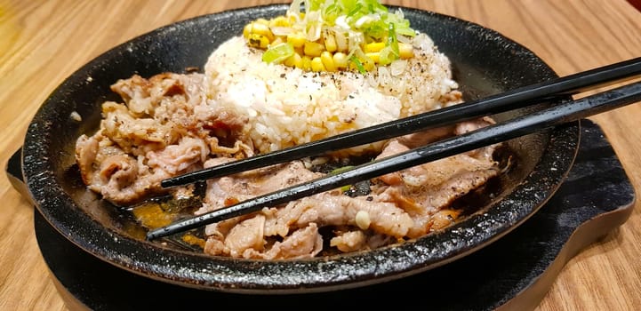 selective focus grilled beef steak with korean sauce bulgogi on top of rice with slice of pepper and sweet corn - korean food style