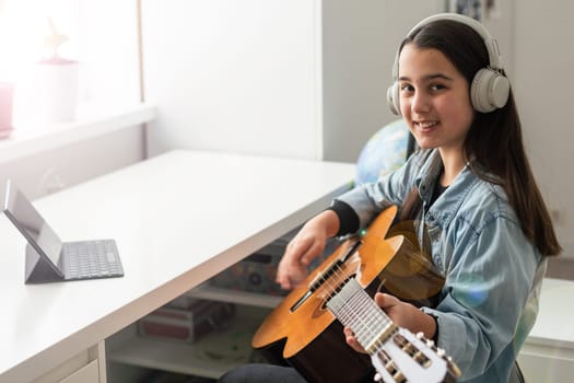 girl giving online guitar lessons, concept study from home online. High quality photo