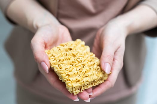 Hand holding yellow noodles dried on white background. High quality photo