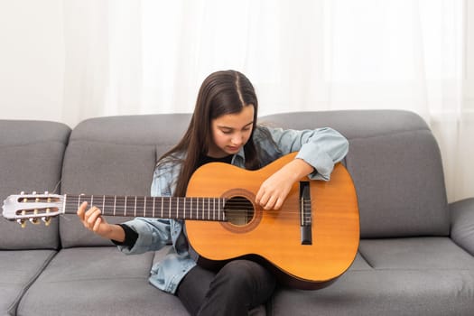 beautiful young girl plays guitar at home. High quality photo