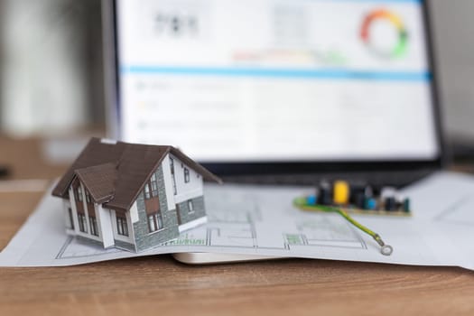 A real estate model and a computer are on the table. High quality photo