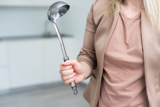 Metal kitchen ladle in hand, isolated on a white background. High quality photo