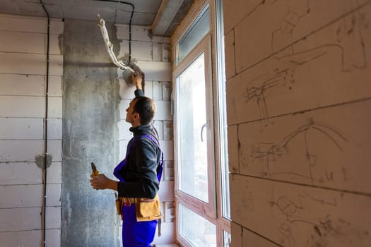 Builder fitting insulation fibre to room walls.