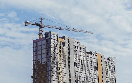 Construction site with crane and building on sky background