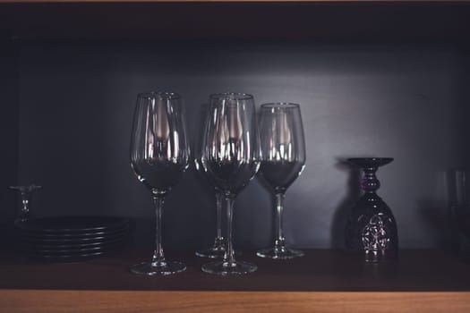 a row of empty glasses and dishes on the restran shelf