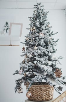 Christmas tree with balls and gifts on the background of a white brick wall