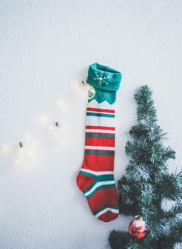 Christmas sock hanging on the wall next to the spruce