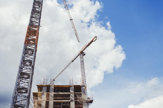 Construction site with cranes on blue sky background