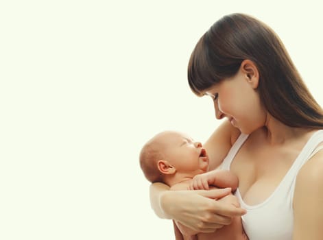Happy young mother holding cute infant, baby sleeping in arms on white studio background