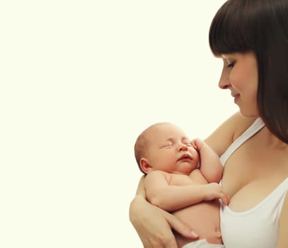 Happy young mother holding cute infant, baby sleeping in arms on white studio background