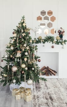 Cozy beautiful modern design of the room in light colors decorated with Christmas tree and decorative elements fireplace