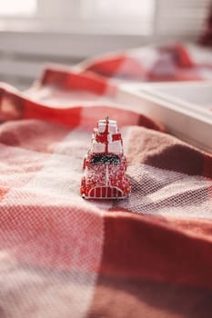 Retro toy red car carrying christmas box on roof 