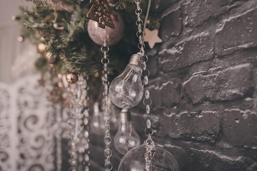 Christmas decor in the room. light bulbs and spruce hanging on a brick wall