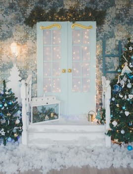 Vintage door with Christmas decorations. Winter terrace of the house with garlands of retro light bulbs
