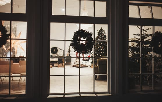 Christmas tree and decoration in the window background. Night scene with a snow and brightly decorated Christmas tree in a window.