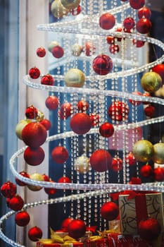 a lot of red hanging balls on the shop window decorated for Christmas