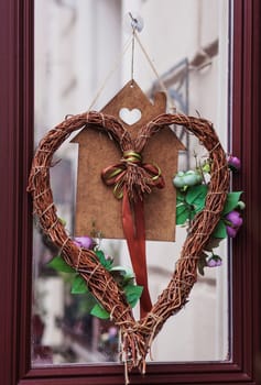 Stylish christmas wreath with red heart, modern decor on store front or building facade