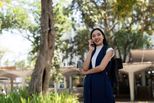 Young happy Asian business woman office professional talk cellphone in walking on city go work.