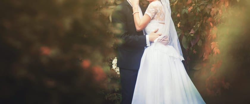 bride and groom hold hands at sunset