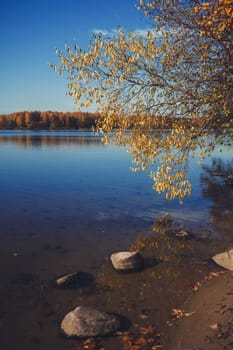 a row of stones on the blue lake. autumn landscape
