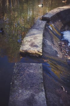 Stepping stones over river and small waterfall.