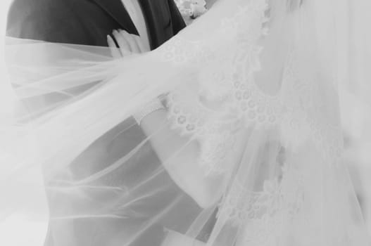 the bride and groom embracing outdoors. black and white portrait of the newlyweds