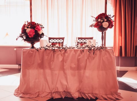 the richly decorated table with flowers. table for the newlyweds