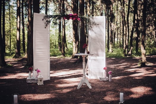 Beautiful wedding ceremony in the open air. Wedding arch in the forest